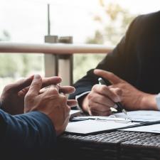 Business Executives discussing about sales performance at a modern outdoor workplace.